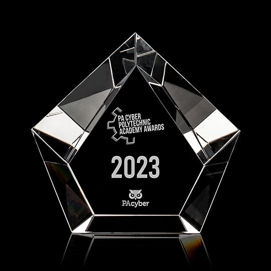The Poly Award, a glass trophy in the shape of a pentagon with the award's title engraved into it