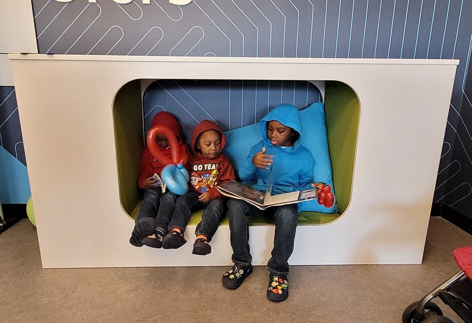 Three students read together in a book nook.